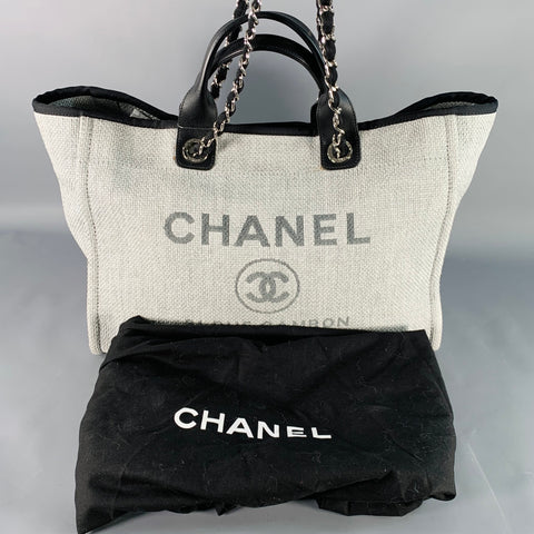 Front view of Chanel logo tote shown with its black Chanel dust bag.