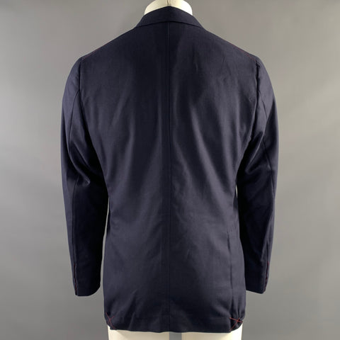 Back view of navy sport coat showing center seam, shoulders, and red stitching at hem corners.