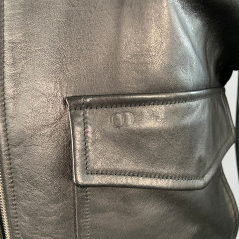 Close-up of black leather flap pocket with embossed Dior detail.
