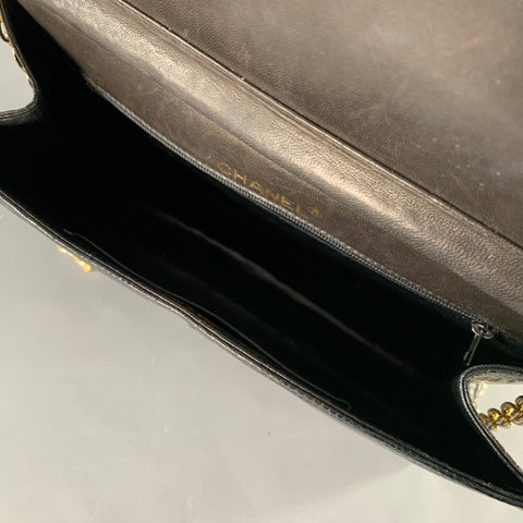 Opposite side view of the black lizard leather bag with gold-tone chain strap.