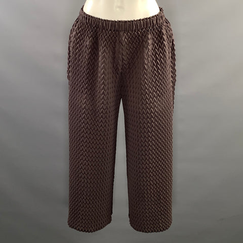 Front close view of elastic waistband and upper legs of brown chevron-pleated pants.