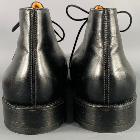 Rear view of both black leather ankle boots showing back seam stitching and heels.
