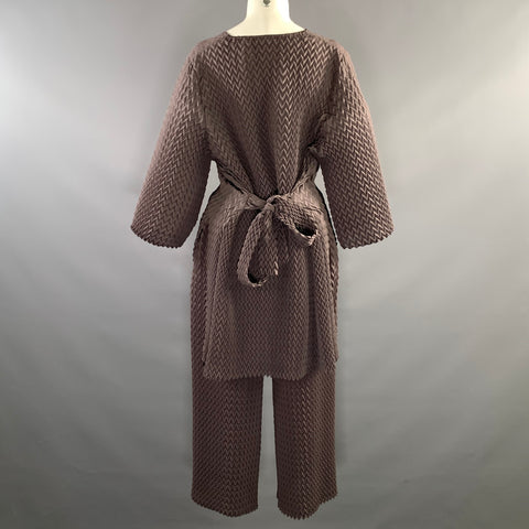 Back view of brown chevron-pleated top with tied belt at waist and matching pants.