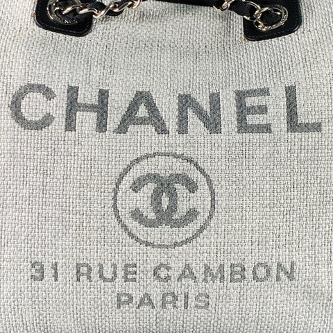 Close front view of the grey woven tote showing the CHANEL wordmark and double-C logo.