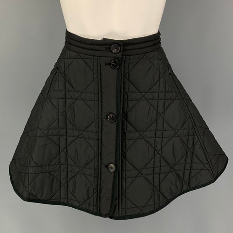 Front view of black quilted Christian Dior mini skirt with button-front placket and zippered side pockets.