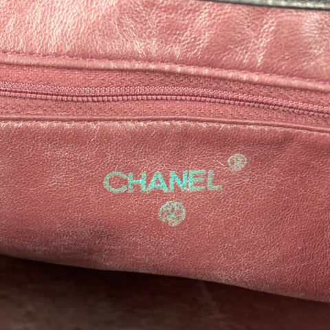 Interior close-up showing burgundy leather lining with Chanel stamp and circular date mark.