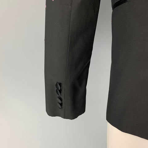 Close-up of black sport coat sleeve cuff with four black fabric-covered buttons.