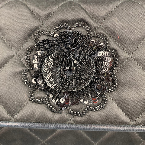 Close-up of the black sequined flower appliqué on the quilted flap.