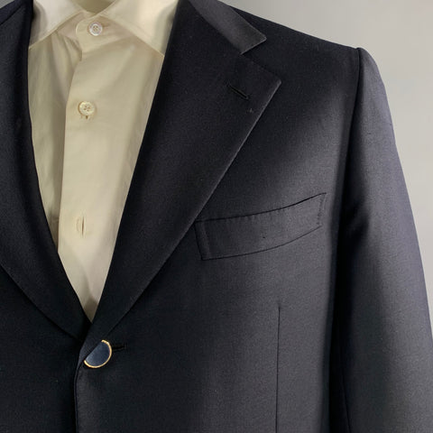 Close-up of navy sport coat notch lapel, buttonhole, chest welt pocket, and navy-covered button.
