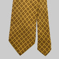 Yellow tie with brown geometric pattern on a light gray background