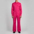 Person wearing a bright pink jumpsuit on a gray background