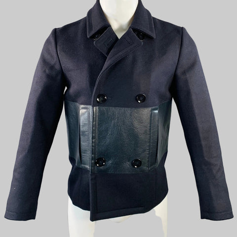 Black peacoat with leather panels on a mannequin against a gray background