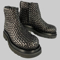 A pair of black BOTTEGA VENETA woven leather boots with side zipper and lug sole.