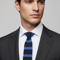 Blue and black striped knitted tie with a label on a gray background