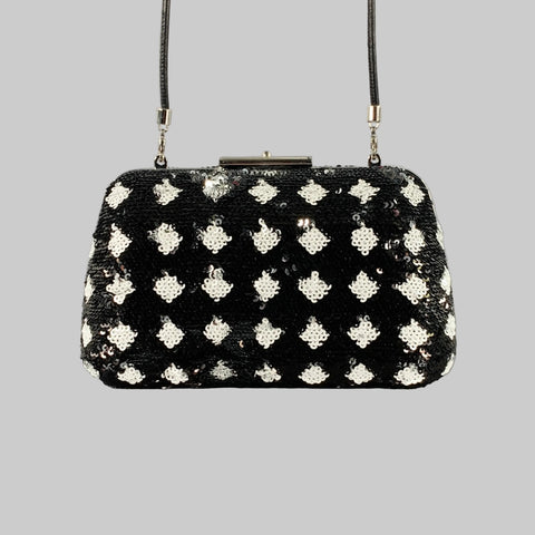 Black handbag with silver floral patterns on a gray background