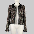 A black and multicolor CHANEL wool blend open front jacket on a mannequin, featuring a spread collar, silk trim, and contrast trim details.