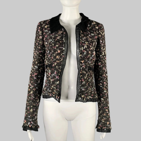 A black and multicolor CHANEL wool blend open front jacket on a mannequin, featuring a spread collar, silk trim, and contrast trim details.