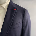 Close-up of navy textured wool sport coat notch lapel with red Isaia lapel pin.