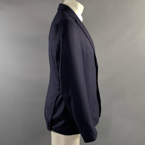 Side view of navy sport coat on mannequin showing long sleeve and patch pocket.
