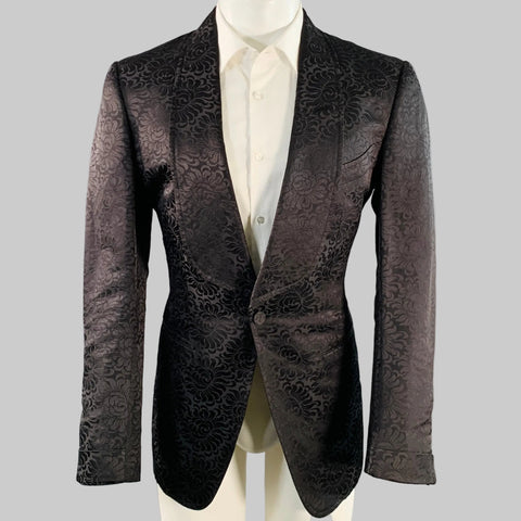 Patterned black jacket on a mannequin against a gray background
