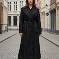 Black trench coat on a mannequin against a gray background