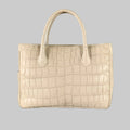 A grey crocodile leather tote handbag with rolled top handles and a snap closure. The handbag appears to be made of a textured leather with a natural grey crocodile pattern.
