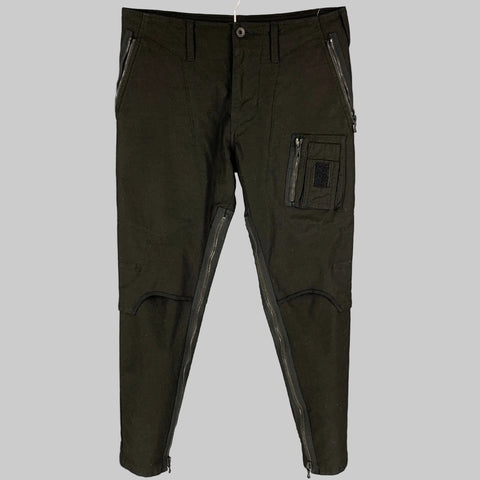 Pair of black slim-fit casual pants with exposed zipper details and a zip fly closure, displayed on a hanger.