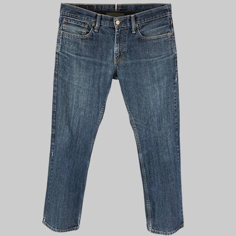 A pair of LEVI STRAUSS size 32 indigo cotton jeans displayed on a hanger, featuring a straight leg cut and a zip fly closure.