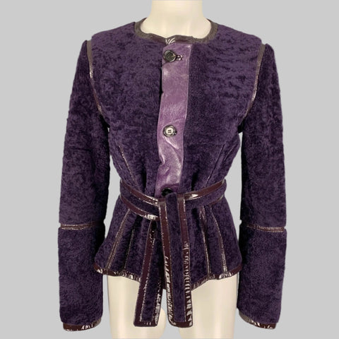 YVES SAINT LAURENT branded purple shearling patent leather reversible belted jacket, displayed on a mannequin, with a buttoned front closure.