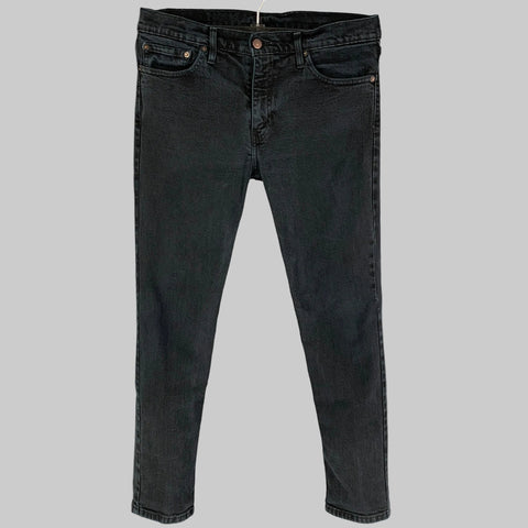 A pair of LEVI STRAUSS black cotton jeans with a slim fit and a zip fly closure, displayed on a hanger.
