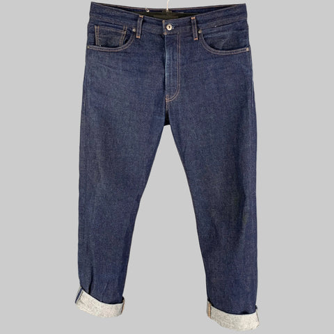 A pair of LEVI'S 551 Z indigo cotton straight jeans with contrast stitching and a button fly, displayed on a hanger.