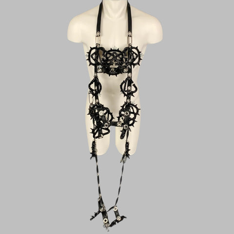 Black PVC rubber harness necklace with silver tone hardware and spike knuckle details, displayed on a mannequin.