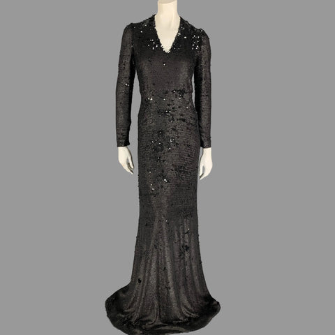 A black sequined column gown dress with long sleeves and a v-neck on a mannequin.