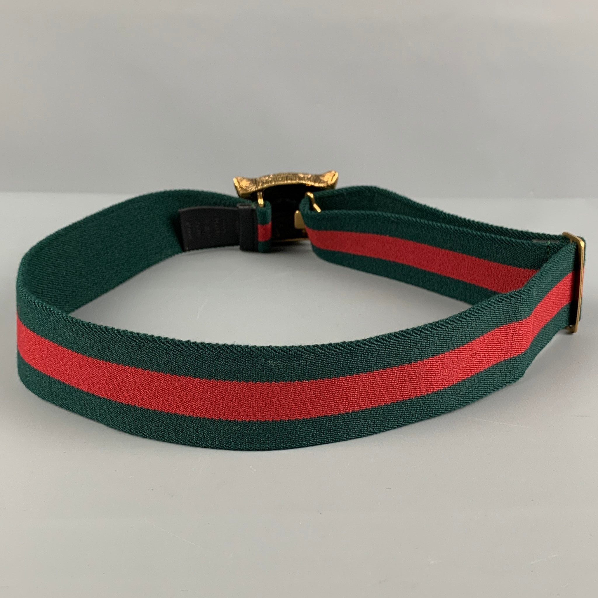 Cinturon con cabeza de felino de laton y tela a rayas en verde rojo y dorado de GUCCI