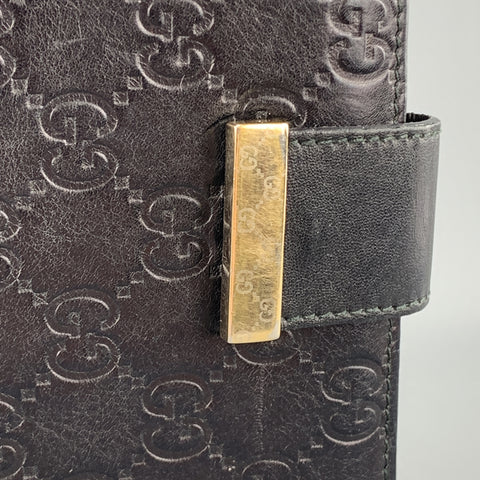 Cartera tipo chequera de cuero negro con monograma en relieve GUCCI